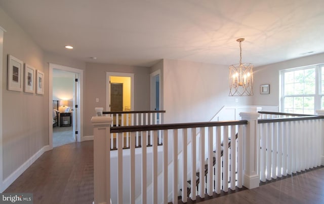 hallway featuring dark hardwood / wood-style floors and a notable chandelier