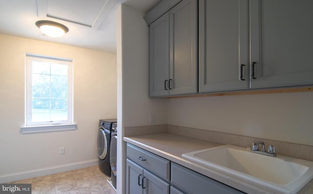 washroom with cabinets, sink, and washing machine and clothes dryer