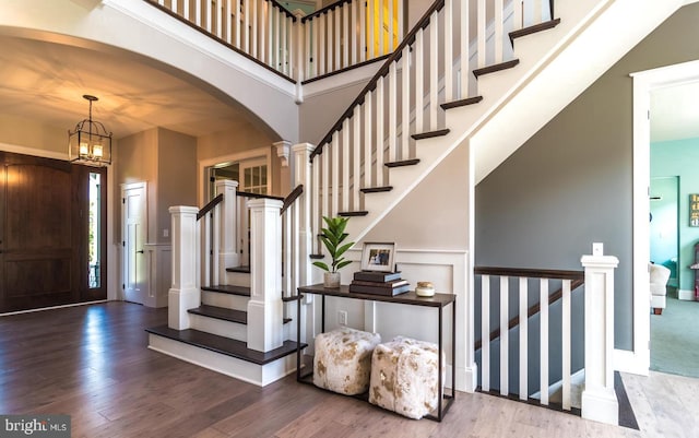 foyer with hardwood / wood-style floors and a chandelier