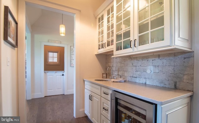 bar featuring white cabinets, wine cooler, pendant lighting, sink, and dark hardwood / wood-style flooring