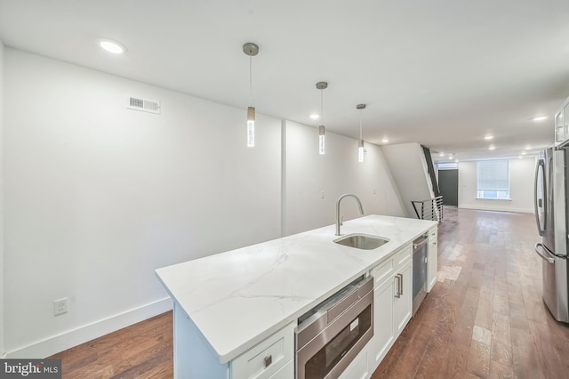 kitchen with a center island with sink, stainless steel appliances, and white cabinets