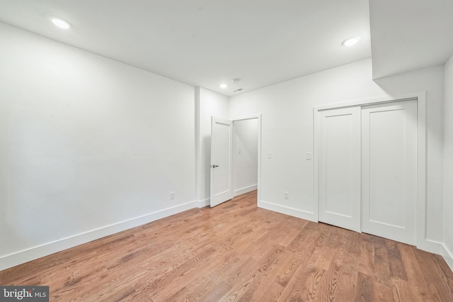 unfurnished bedroom featuring light hardwood / wood-style flooring and a closet