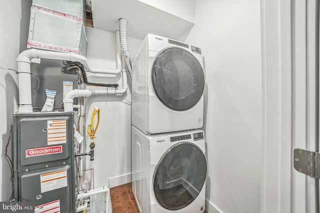 washroom with stacked washing maching and dryer and dark hardwood / wood-style flooring