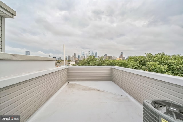 view of patio featuring cooling unit and a balcony