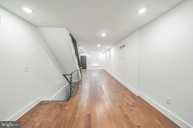 corridor with hardwood / wood-style flooring