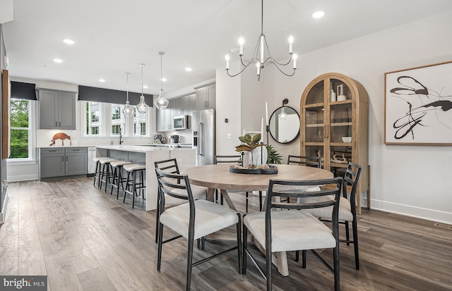 dining area featuring a notable chandelier and dark wood-type flooring