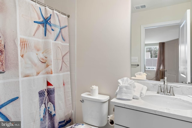 bathroom with curtained shower, vanity, and toilet