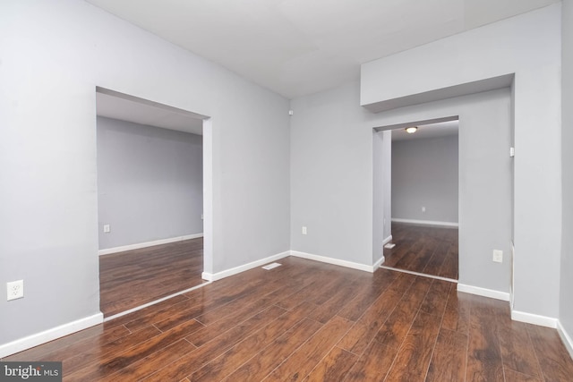 empty room with dark hardwood / wood-style flooring