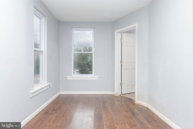 unfurnished room featuring dark wood-type flooring