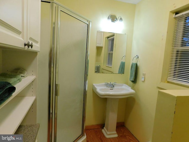 bathroom featuring an enclosed shower, hardwood / wood-style flooring, and sink