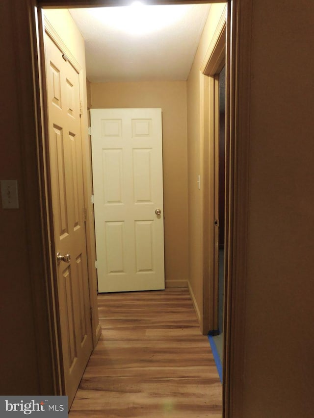 corridor with hardwood / wood-style flooring