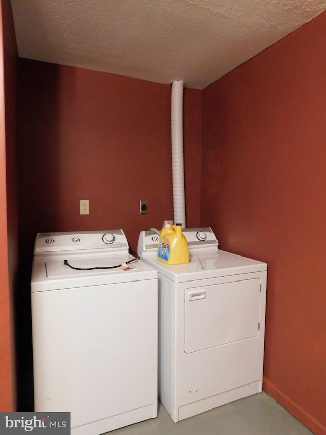 clothes washing area featuring independent washer and dryer and a textured ceiling