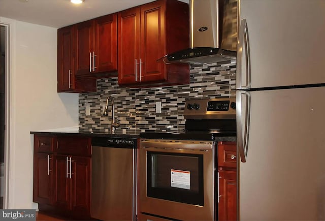 kitchen featuring appliances with stainless steel finishes, wall chimney exhaust hood, sink, and tasteful backsplash