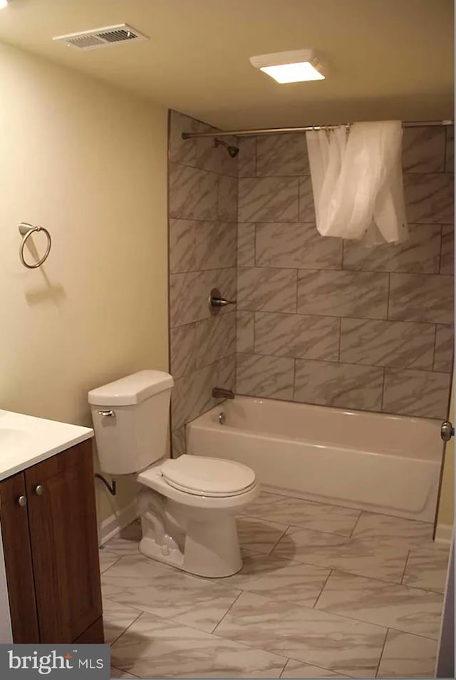 full bathroom featuring vanity, tiled shower / bath combo, and toilet