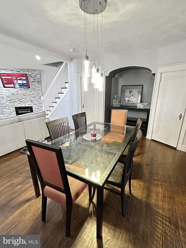 dining area with dark hardwood / wood-style floors and a fireplace