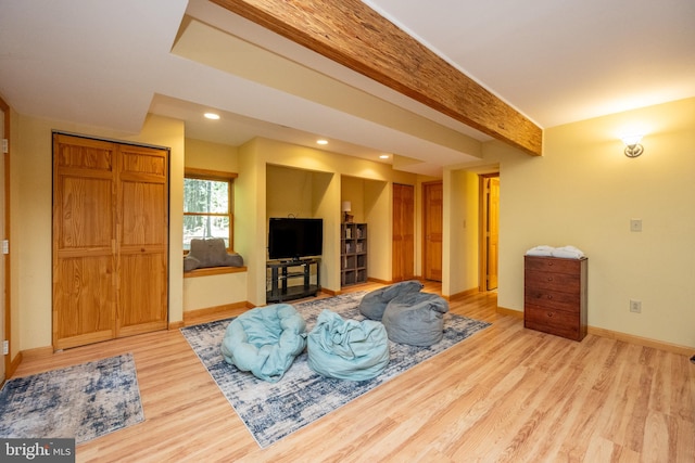 interior space with light hardwood / wood-style flooring and beam ceiling