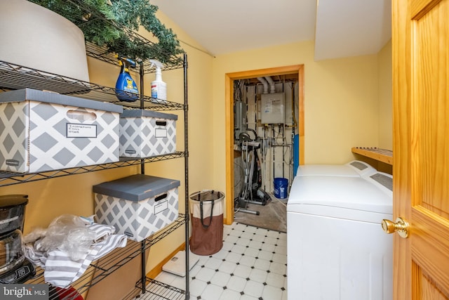 washroom with water heater and washing machine and dryer