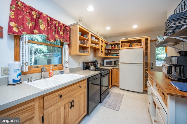 kitchen with black appliances, sink, and butcher block counters