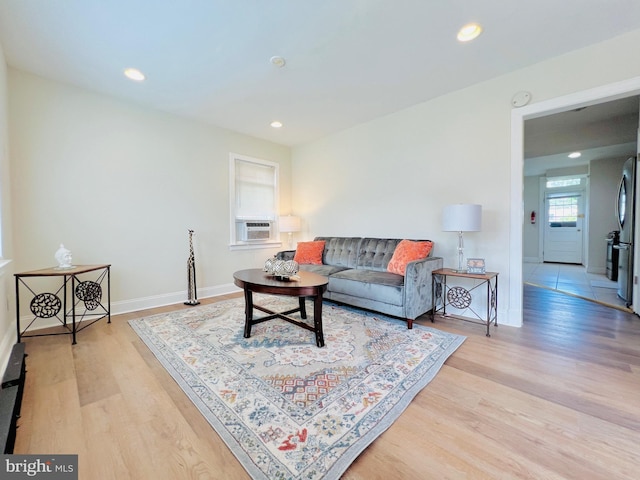 living room featuring a healthy amount of sunlight, light hardwood / wood-style flooring, and cooling unit