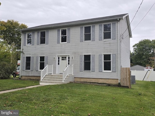 colonial home with central AC unit and a front yard