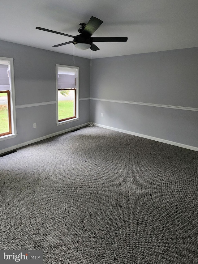 carpeted spare room featuring ceiling fan and a wealth of natural light