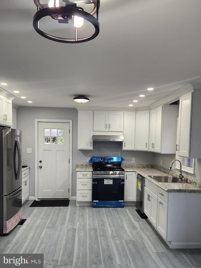 kitchen featuring white cabinets, appliances with stainless steel finishes, sink, and light hardwood / wood-style flooring