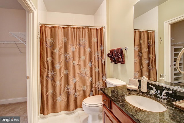 bathroom with curtained shower, vanity, and toilet