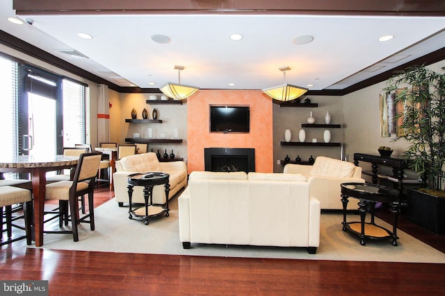 living room with wood-type flooring and ornamental molding