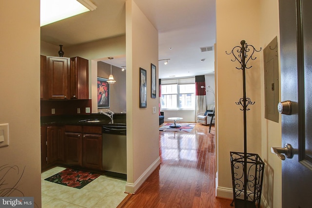 kitchen featuring dishwasher, light hardwood / wood-style floors, hanging light fixtures, and sink