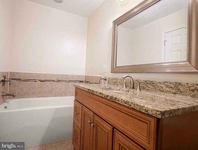 bathroom featuring tile patterned flooring, vanity, and a tub