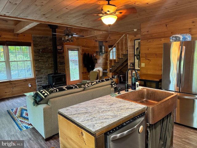 kitchen featuring stainless steel appliances, ceiling fan, a kitchen island, and dark hardwood / wood-style flooring