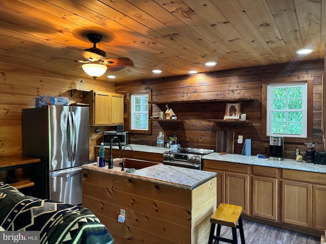 kitchen with stainless steel appliances, wood walls, and dark hardwood / wood-style floors