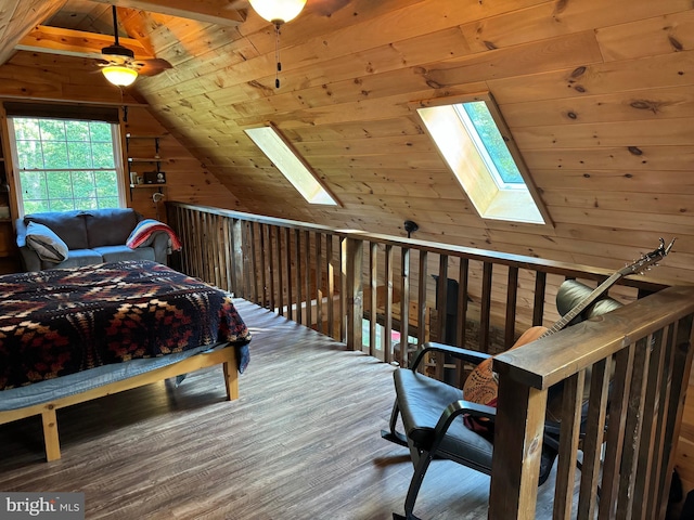 bedroom with vaulted ceiling with skylight, hardwood / wood-style flooring, wooden walls, ceiling fan, and wooden ceiling