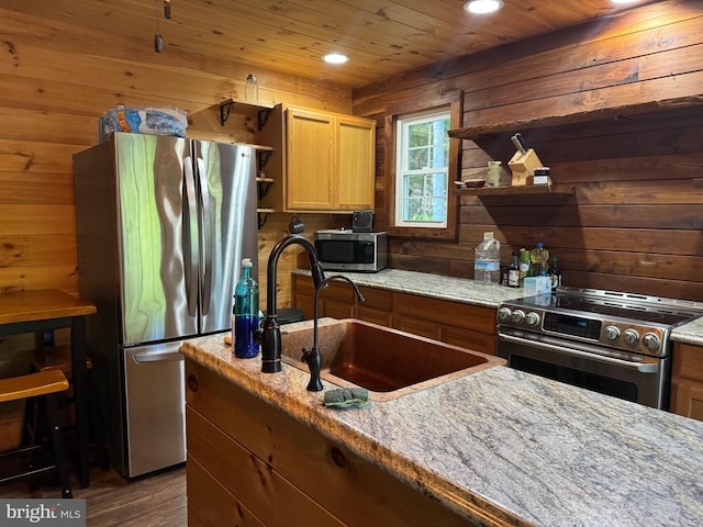 kitchen with light stone counters, stainless steel appliances, wood walls, and dark wood-type flooring