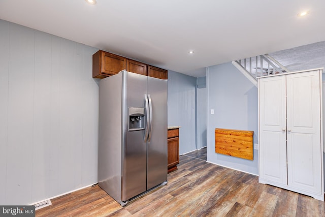 kitchen with dark hardwood / wood-style floors and stainless steel fridge with ice dispenser