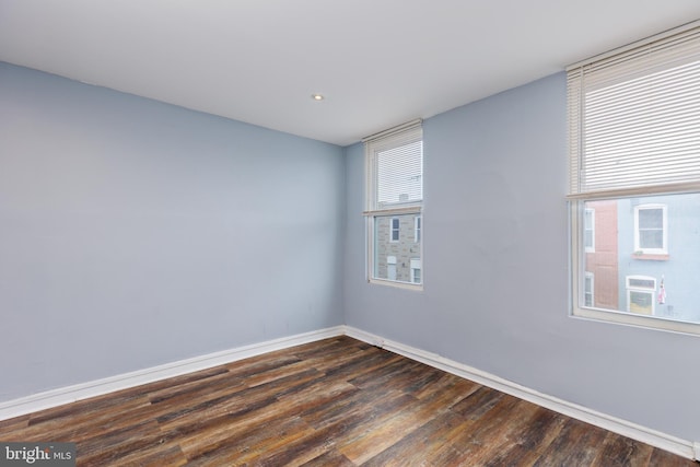 unfurnished room with dark hardwood / wood-style flooring