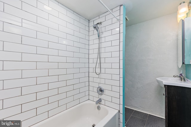 bathroom featuring vanity and tiled shower / bath