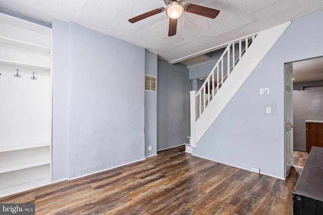 interior space featuring ceiling fan, dark hardwood / wood-style flooring, and a textured ceiling