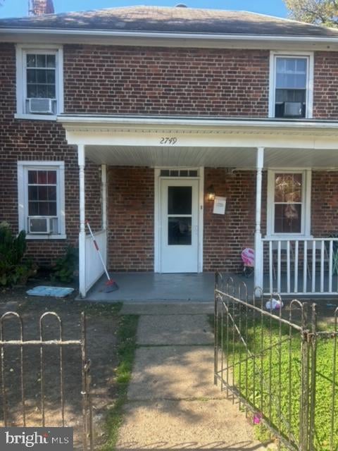 property entrance with cooling unit and a porch