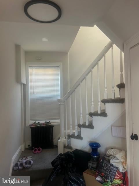 stairway featuring radiator heating unit