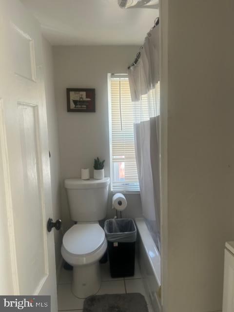 bathroom featuring tile patterned flooring, curtained shower, vanity, and toilet