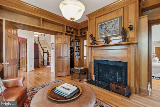 living room featuring crown molding and light hardwood / wood-style flooring