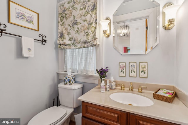 bathroom featuring a chandelier, vanity, and toilet