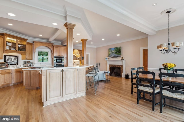 kitchen with light hardwood / wood-style flooring, a tile fireplace, and a kitchen island