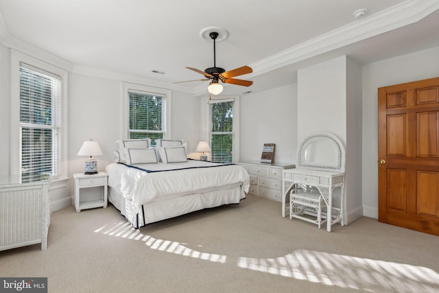 carpeted bedroom with ceiling fan, crown molding, and multiple windows