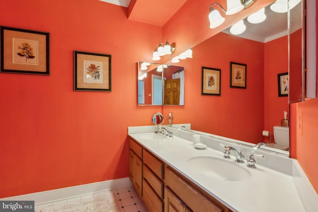 bathroom with ornamental molding, vanity, and toilet