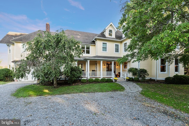 view of front facade with a front yard and covered porch