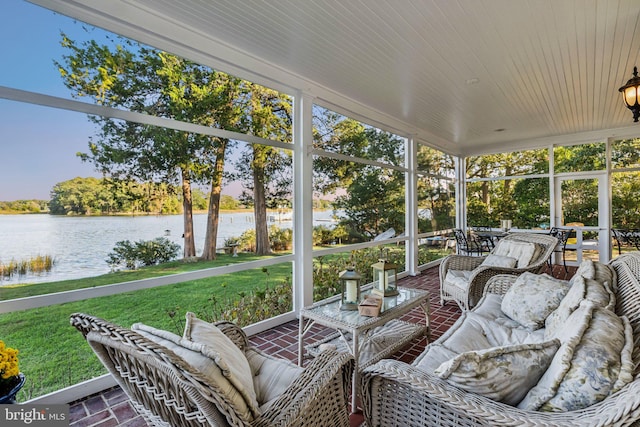 sunroom featuring a water view