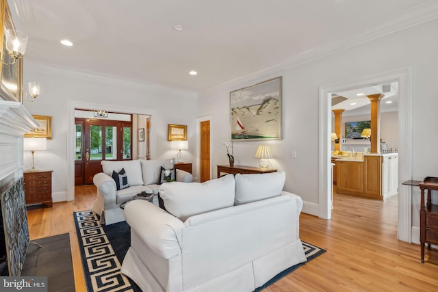 living room with light hardwood / wood-style flooring and crown molding