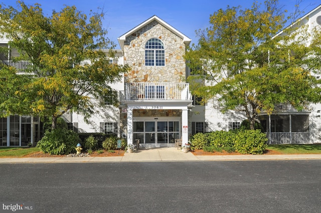 view of front facade featuring a sunroom, a balcony, and a carport